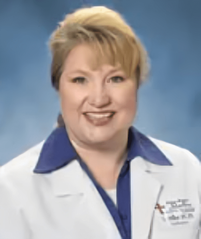 A woman in white lab coat smiling for the camera.