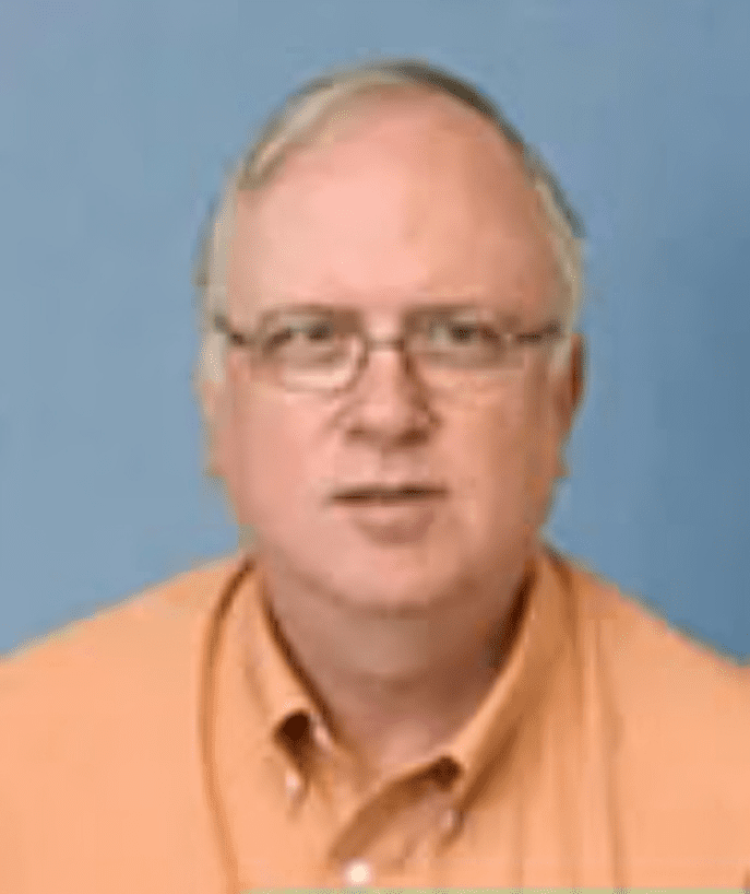 A man with glasses and a yellow shirt