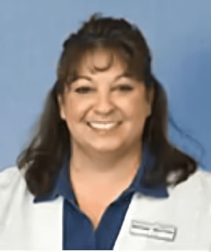 A woman in white coat smiling for the camera.