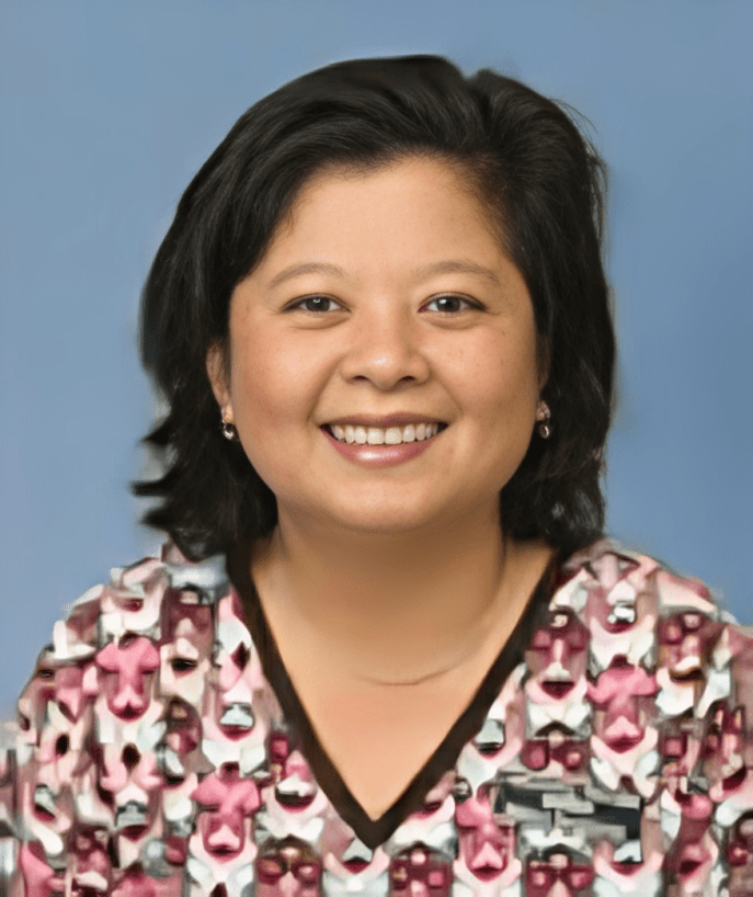 A woman in pink and white shirt smiling for the camera.