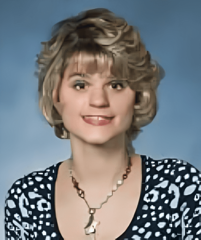 A woman with blonde hair and wearing a necklace.