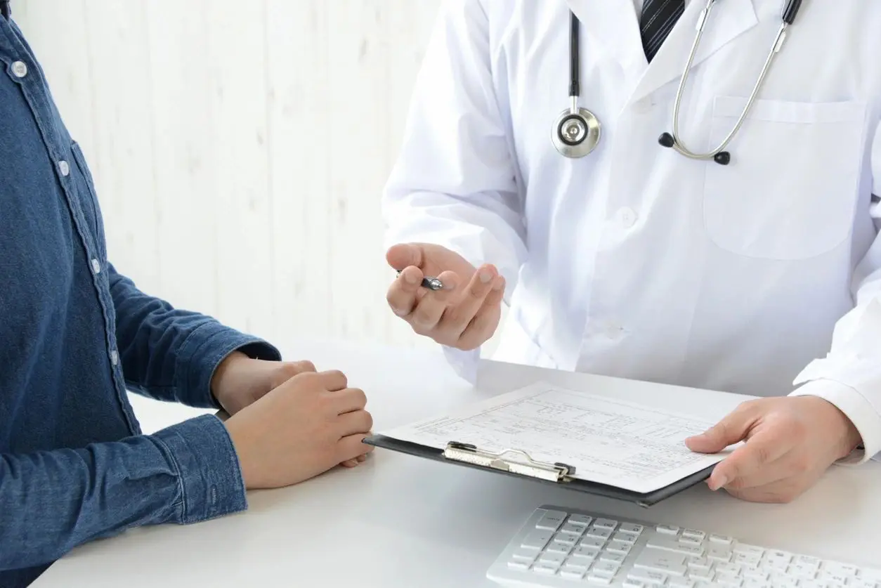 A doctor and patient are sitting at the table.