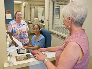 A woman is handing something to another person.